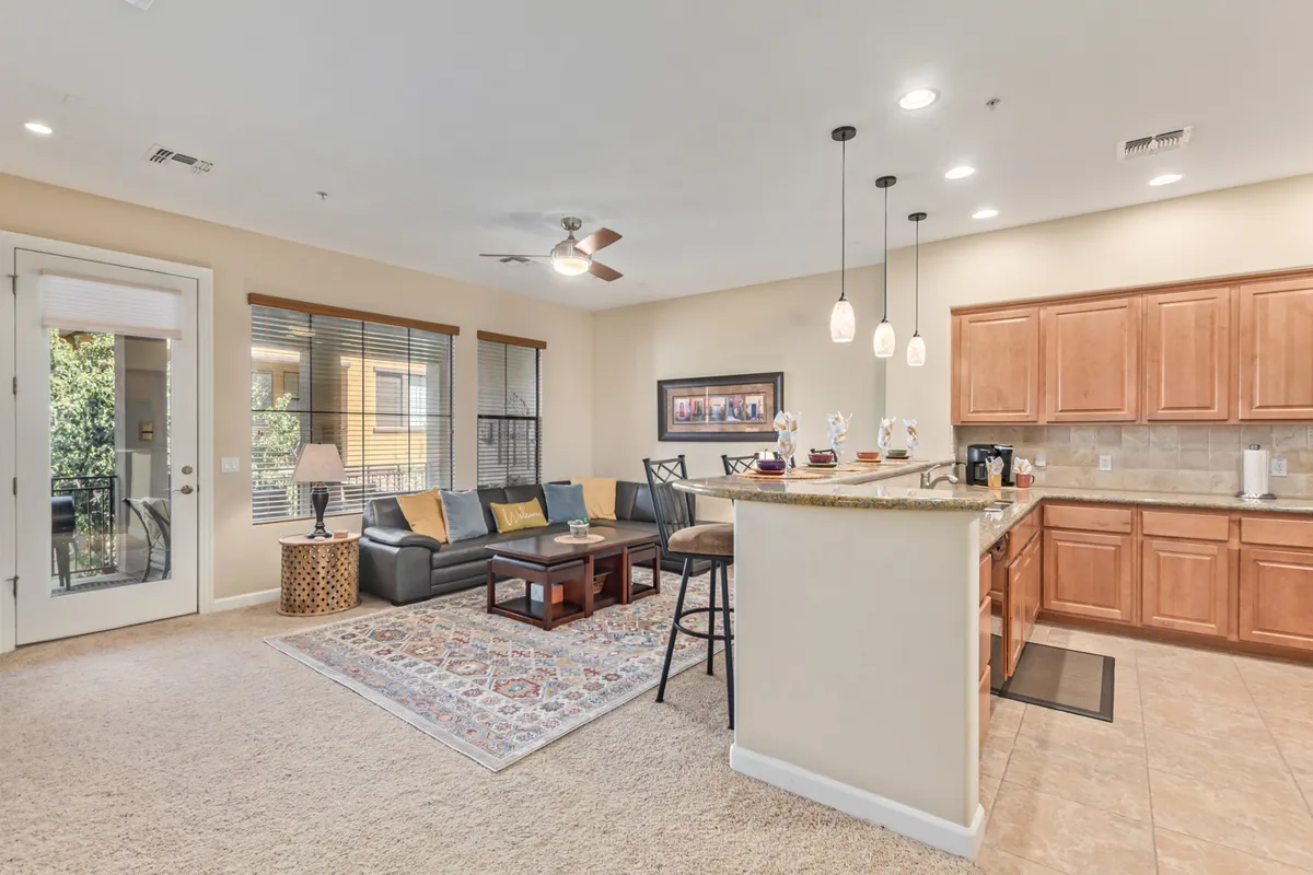 A spacious, open-plan living area with a comfortable sofa, a modern coffee table, a large kitchen island, and stylish pendant lighting. The layout encourages family relaxation and social gatherings, showcasing the convenience of open-concept living.