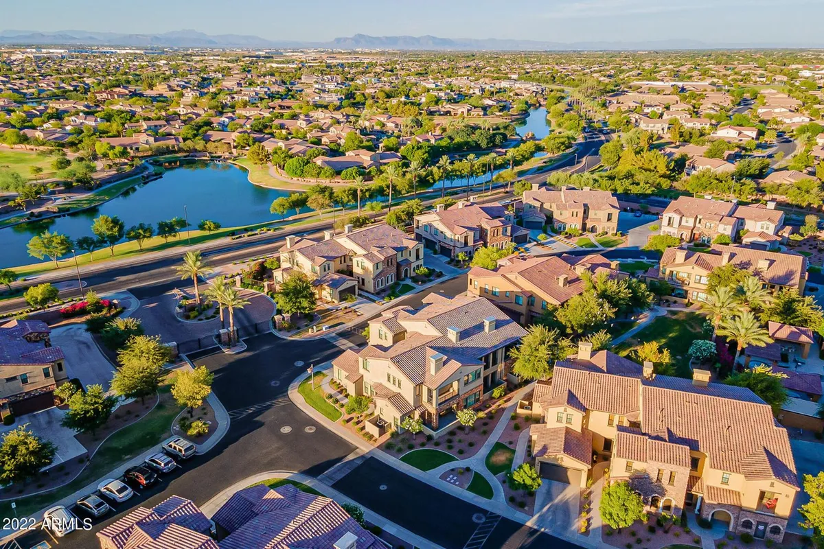 A peaceful neighborhood scene featuring lush landscaping, a meandering waterway, palm trees, and well-maintained homes. The area is perfect for leisurely walks, cycling, or enjoying time with your pet by the water in a community-oriented environment.